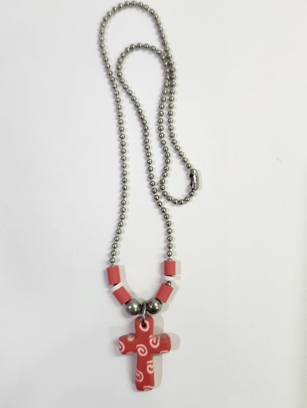 Red and White Patterned Cross pendant on a silver-toned ball chain necklace